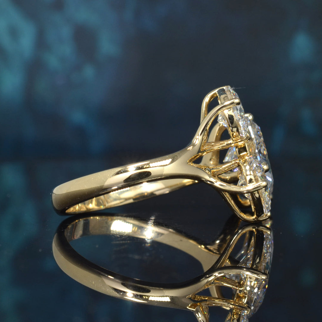 A yellow gold ring with a large round-cut clear gemstone in a prong setting, displayed on a reflective dark blue surface.