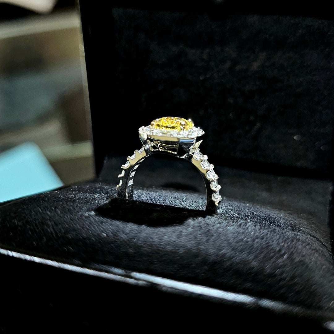 Cushion Yellow diamond with Halo baguette and Round cut Ring in white gold on a ring box side view