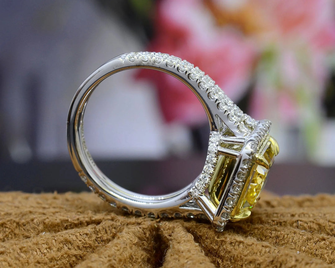 square radiant cut yellow diamond set at the center of a halo split‑shank ring, crafted in white gold and secured with yellow‑gold prongs side profile
