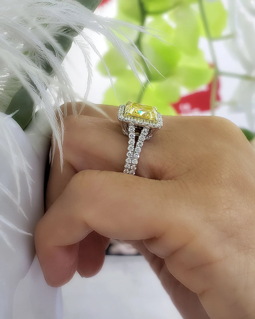square radiant cut yellow diamond set at the center of a halo split‑shank ring, crafted in white gold and secured with yellow‑gold prongs on model's ring finger