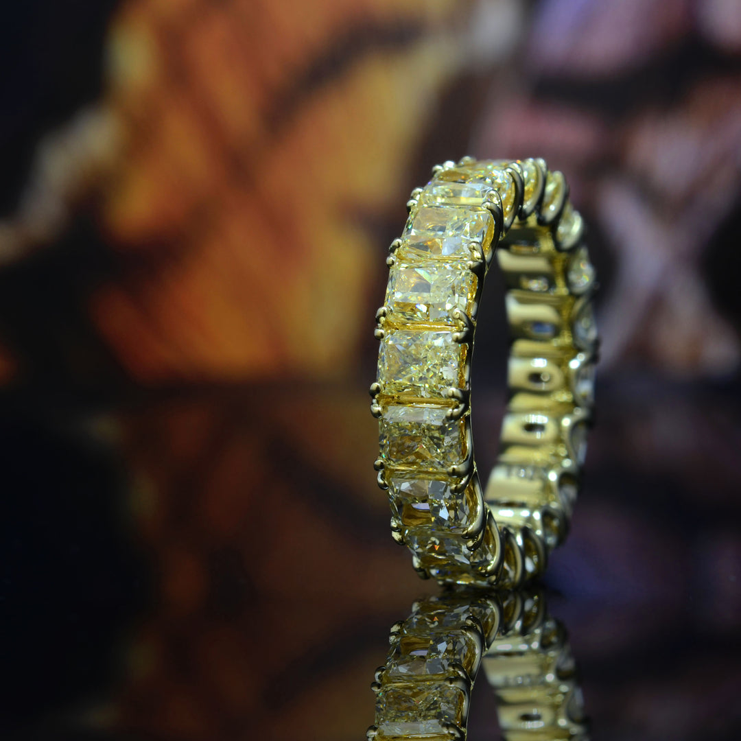 Gold ring with diamond accents on a reflective surface