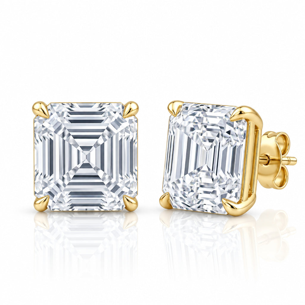 A pair of square emerald cut diamond stud earrings in yellow gold settings, shown from the front and side on a reflective white background