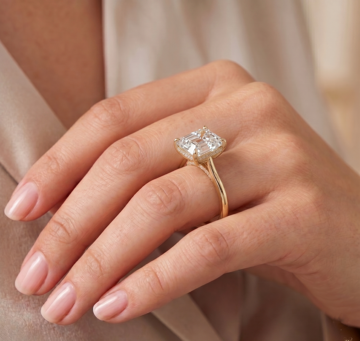 Asscher cut hidden halo diamond ring in yellow gold on model's hand
