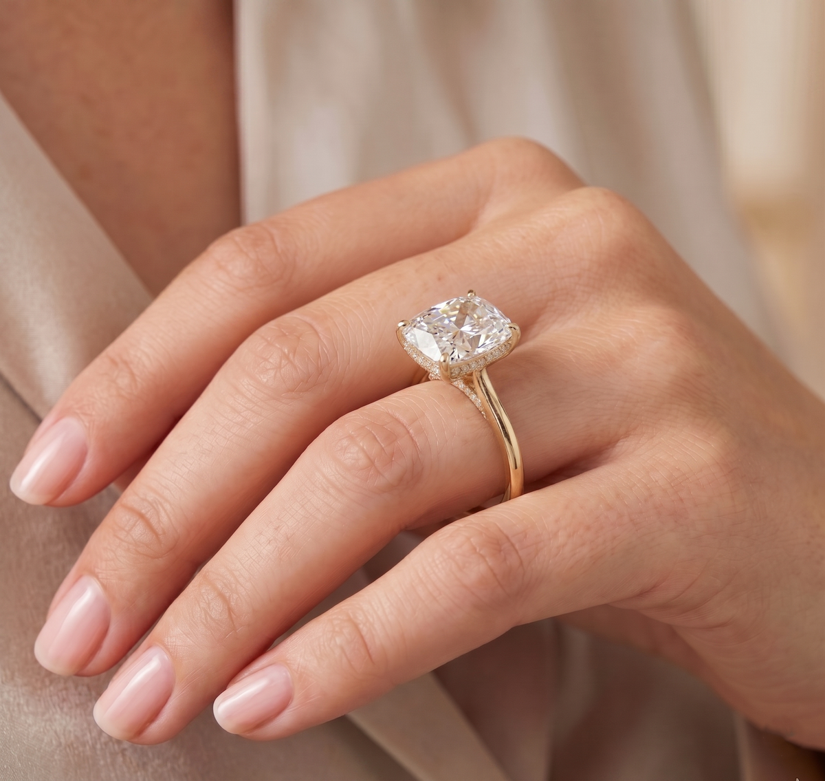 Cushion cut hidden halo diamond ring on model's ring finger