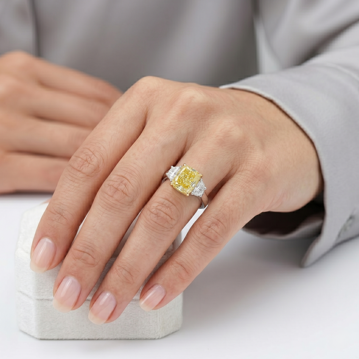 Elongated yellow cushion with halfmoon 3 stone ring in white gold on model ring finger
