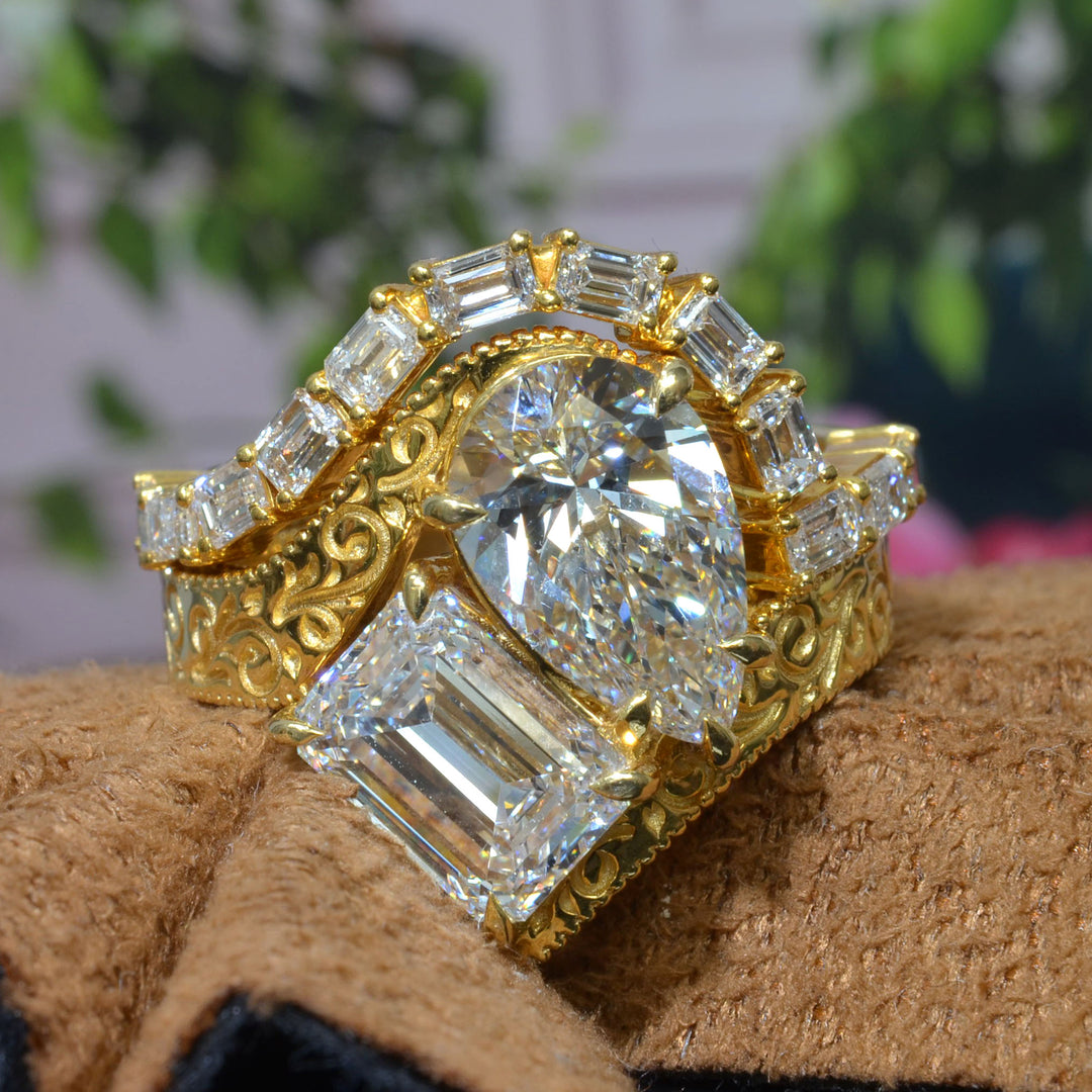 Toi et Moi Emerald & Pear Diamond Bypass Ring with engraving details on shank with curved emerald cut matching band in yellow gold front view
