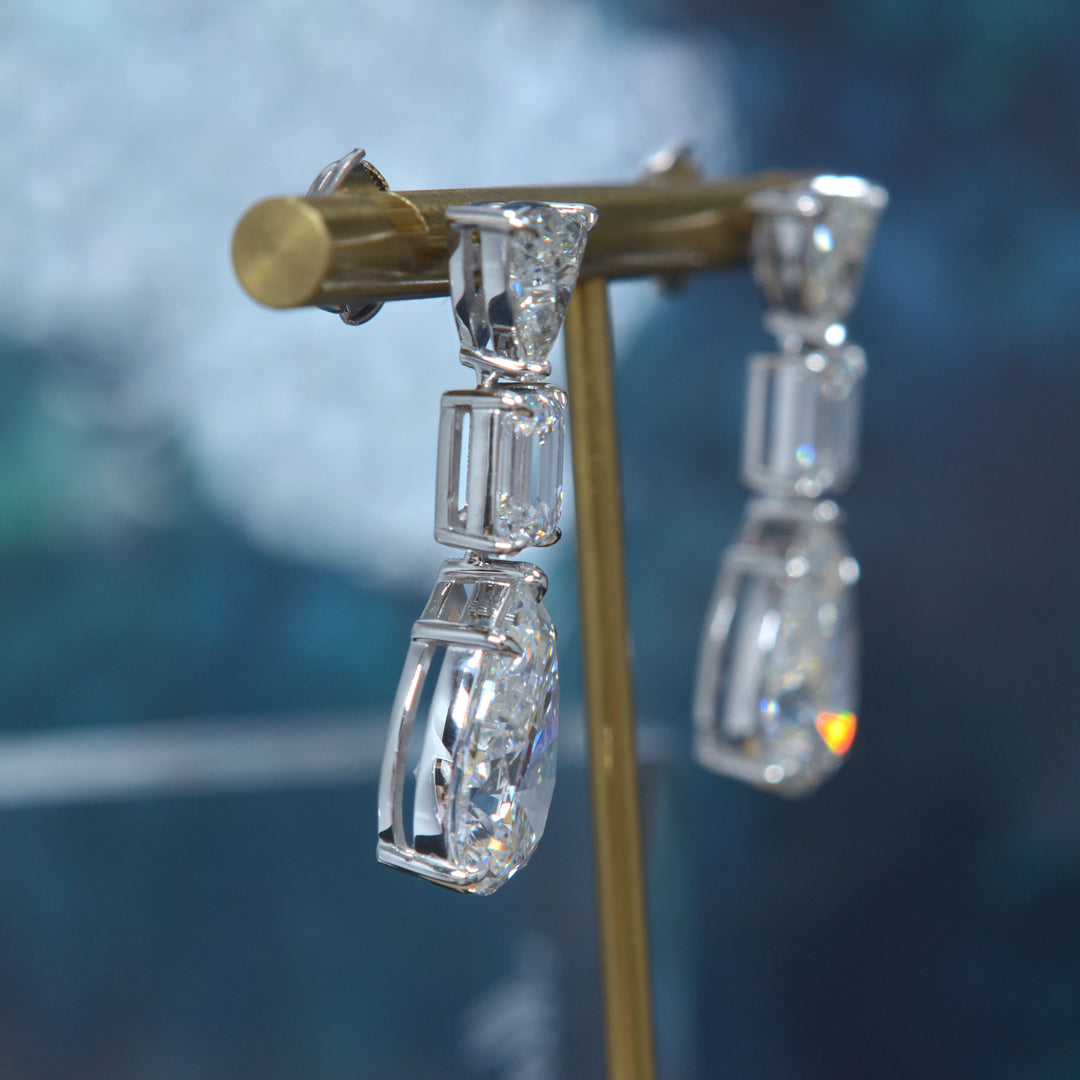 Pear cut, emerald cut and trillion diamond dangling earrings in white gold side view
