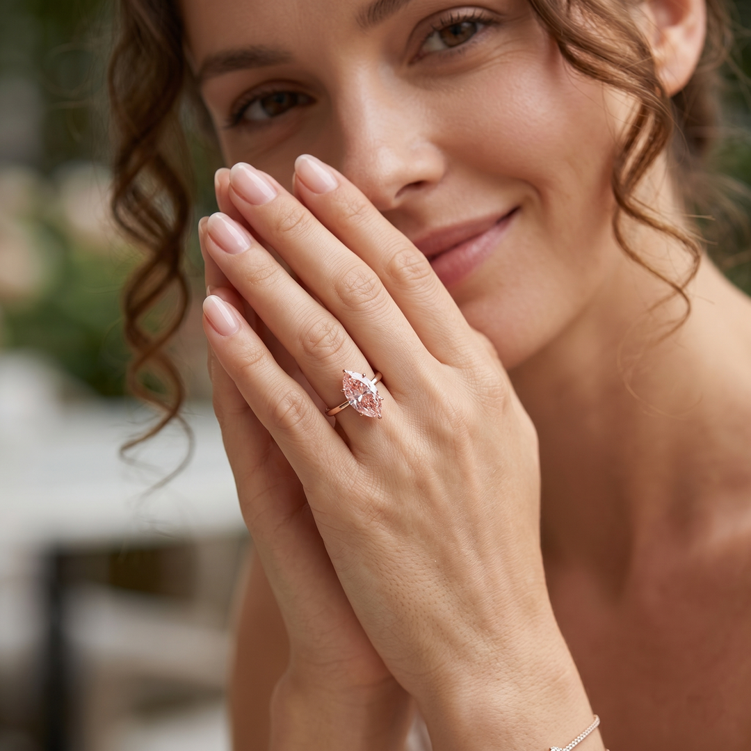 Marquise Fancy vivid pink center diamond solitaire ring in rose gold on model's ring finger