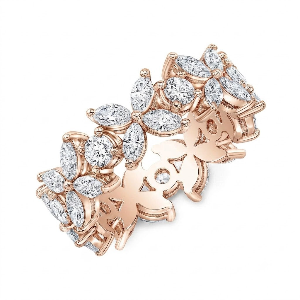 A rose gold band ring featuring a continuous floral design set with clear marquise and round-cut gemstones, shown on a plain white background.