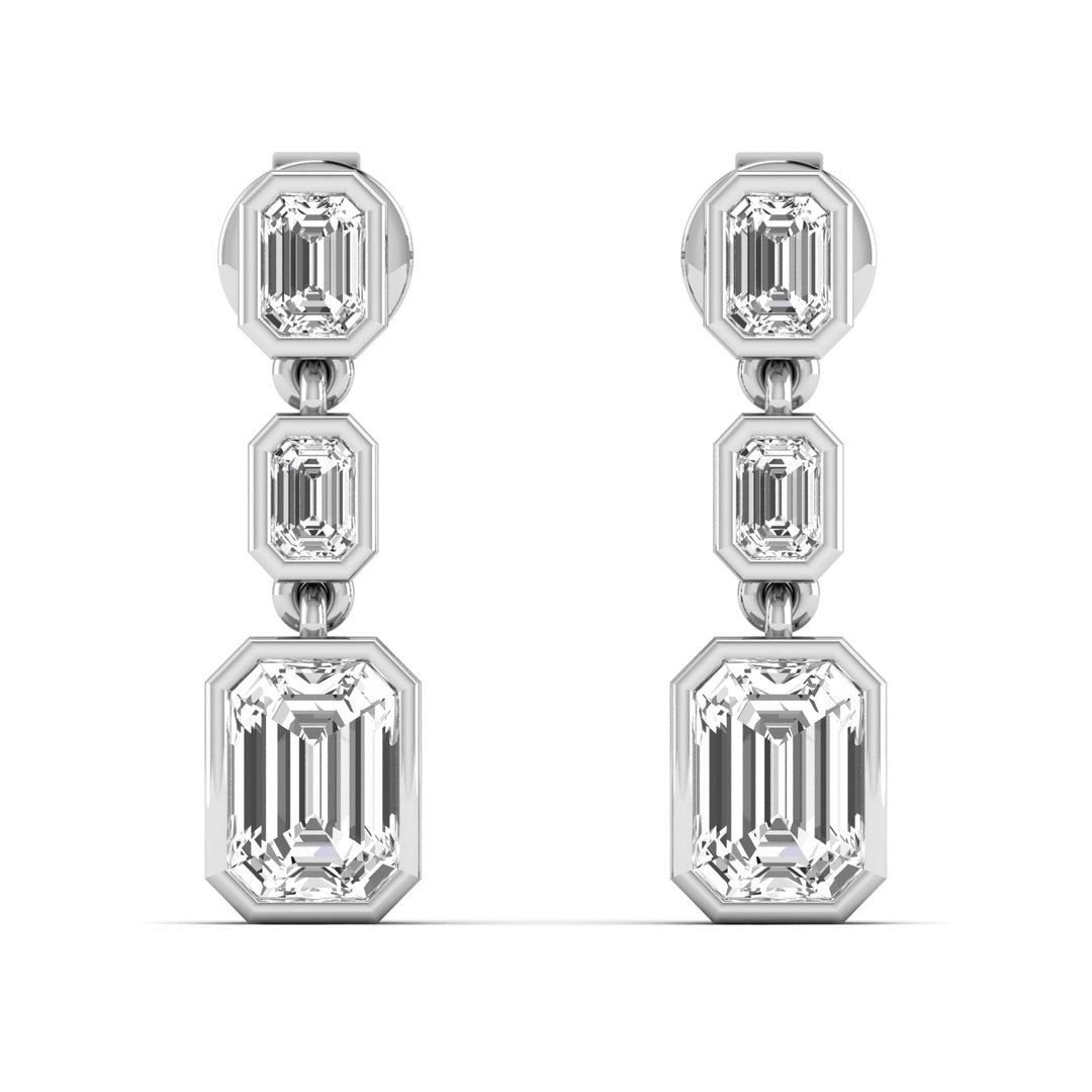 3 Emerald cut diamond dangling bezel set earrings in white gold.
