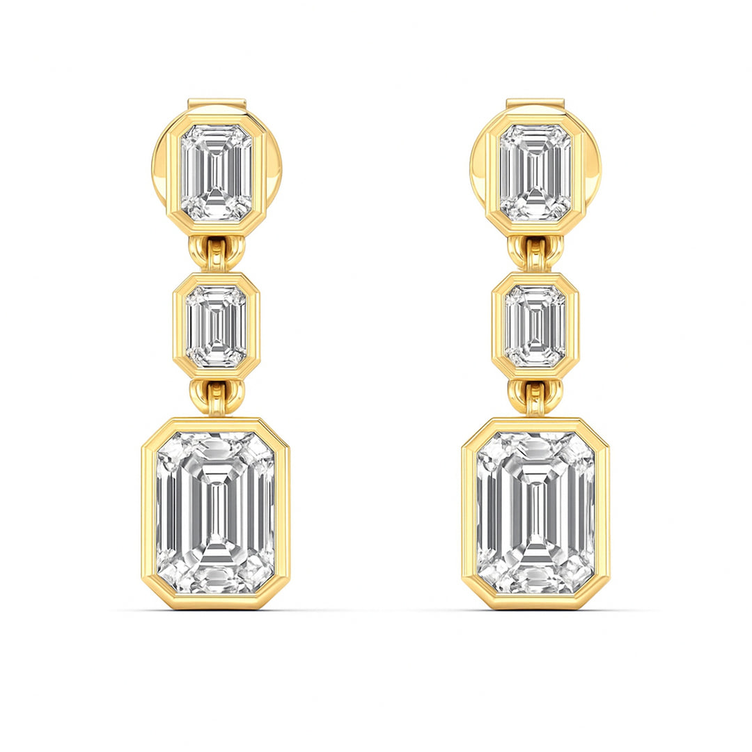 3 Emerald cut diamond dangling bezel set earrings in yellow gold