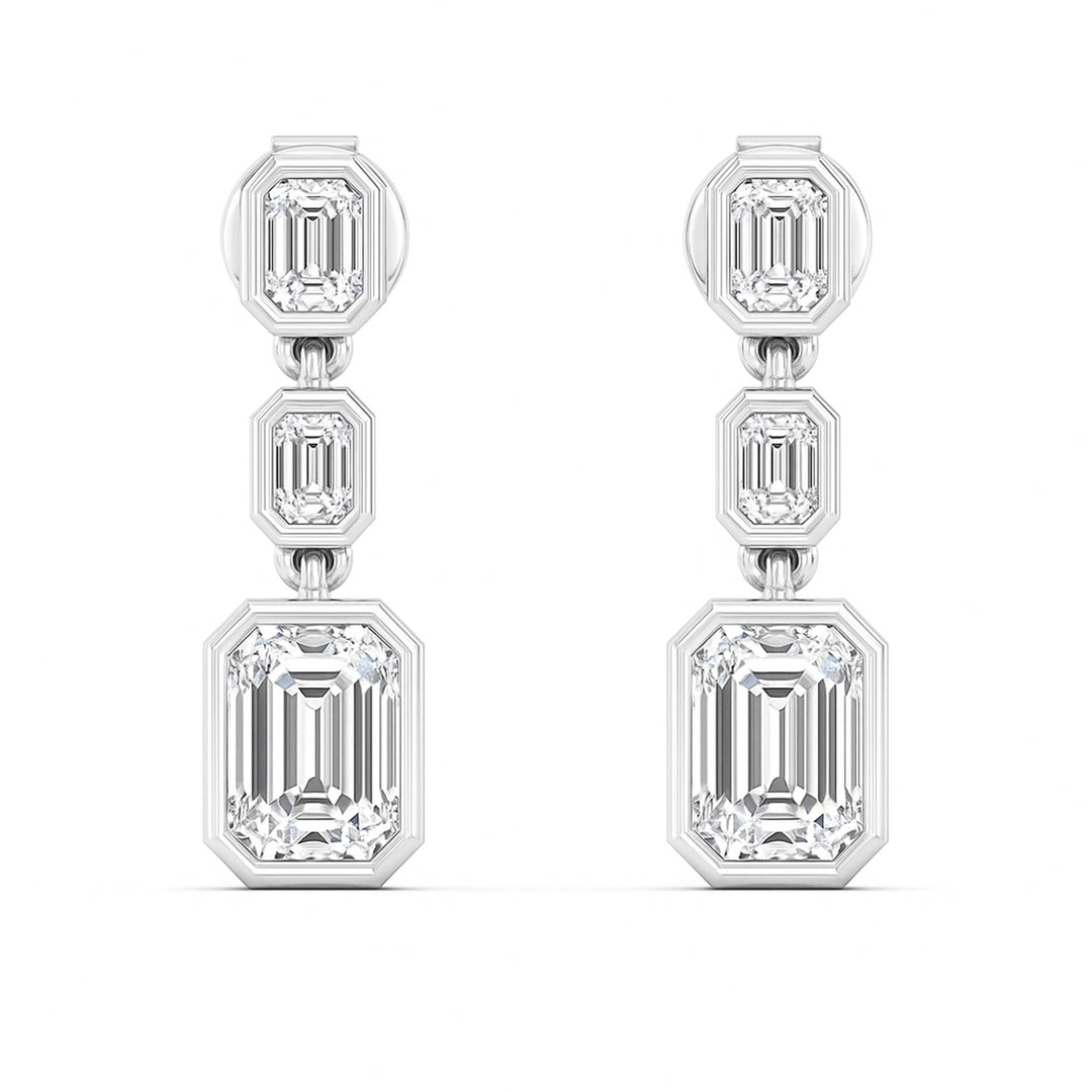 3 Emerald cut diamond dangling bezel set earrings in white gold