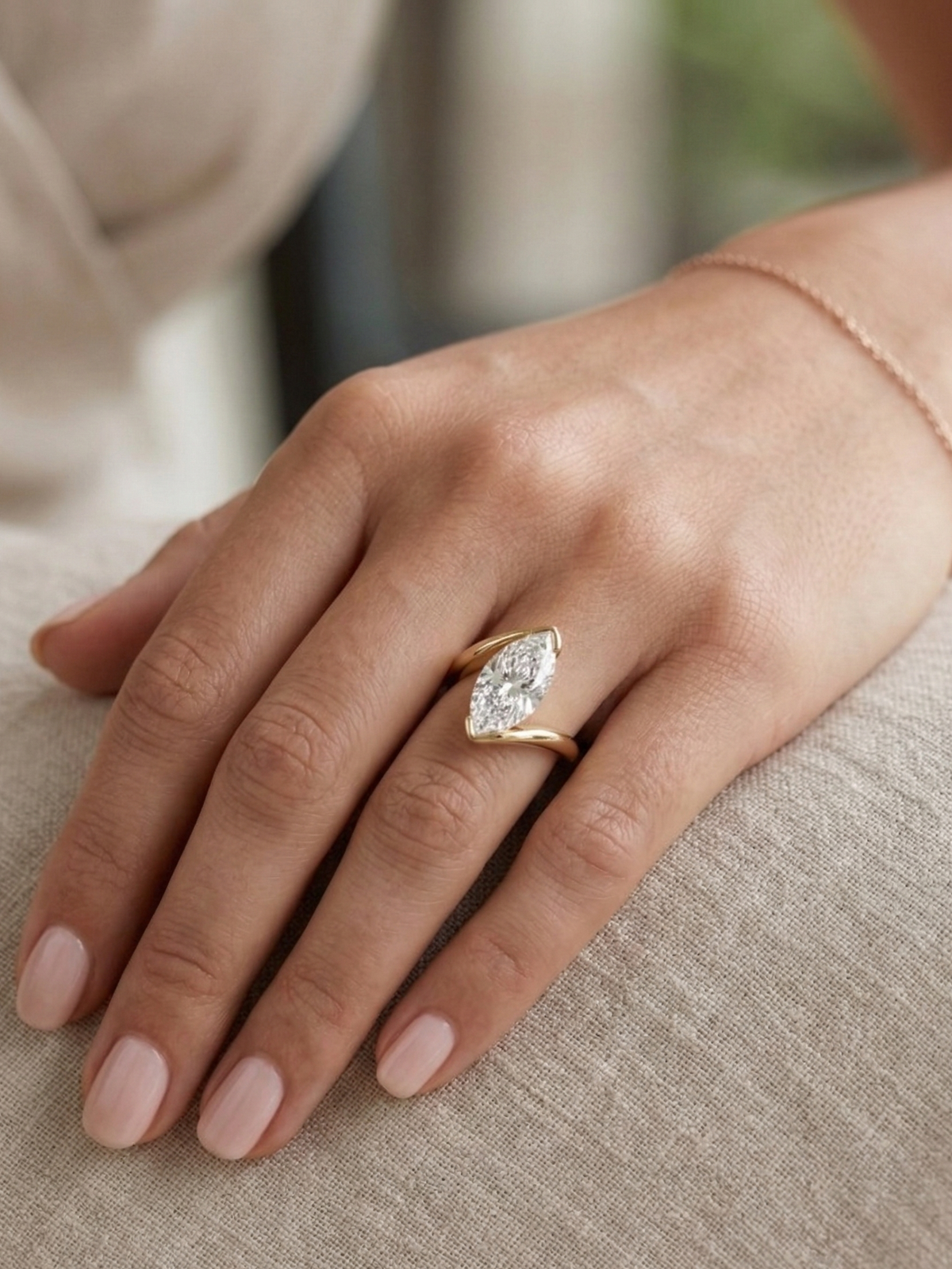 Marquise diamond center solitaire bypass ring in yellow gold on model's hand