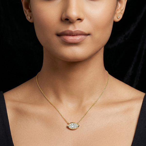 Woman wearing a gold Marquise Diamond necklace with a diamond pendant against a black background