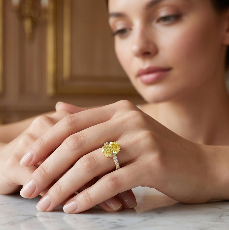 Oval Cut Diamond with Round Cut Pave in yellow gold on finger with model face