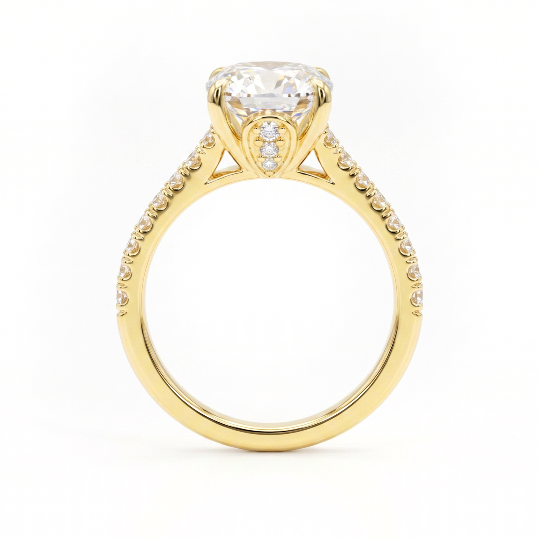 A yellow gold engagement ring featuring a large oval brilliant-cut center stone and a shank pavé-set with small diamonds, side view, shown on a plain white background.