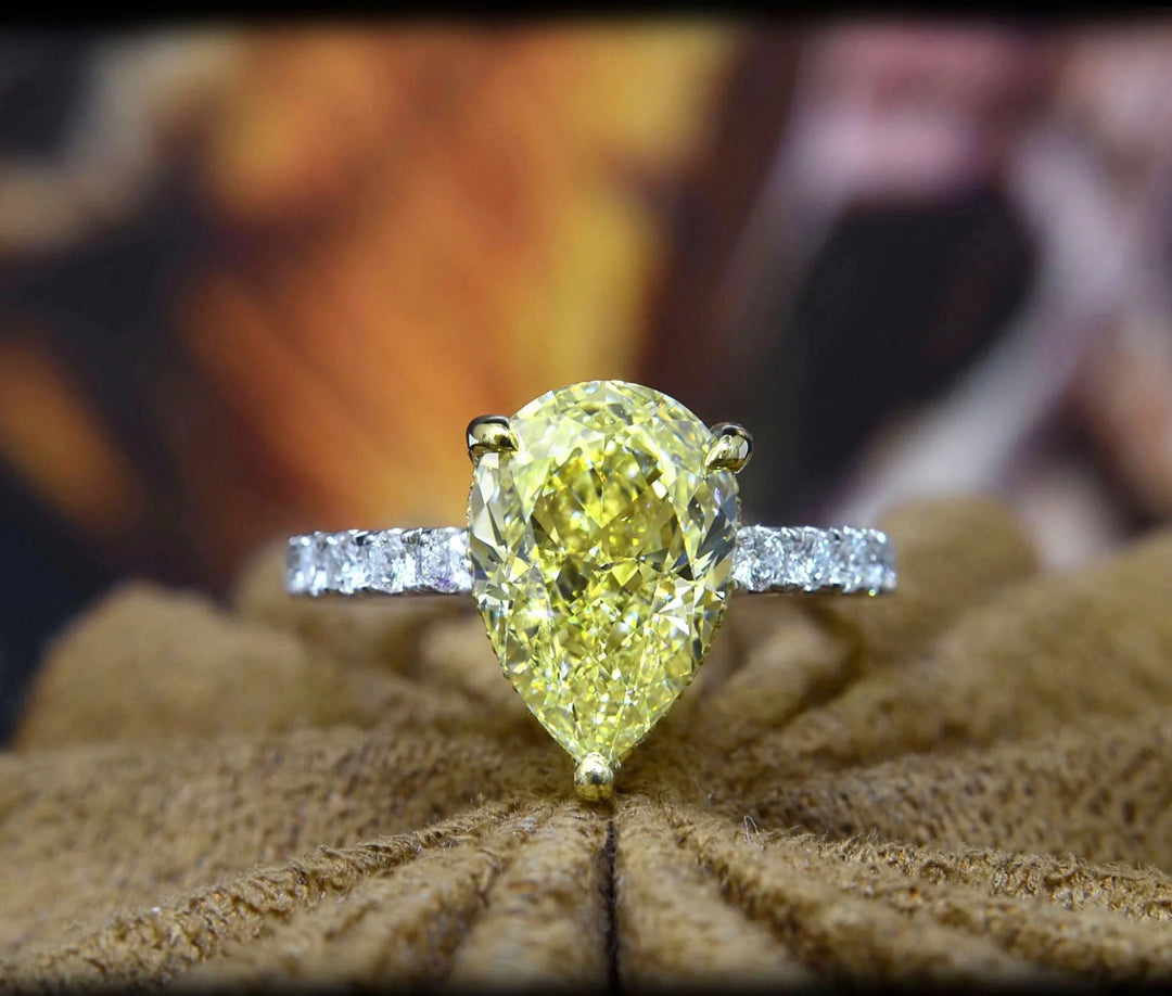 Yellow Pear cut center diamond ring in white gold with yellow gold prongs
