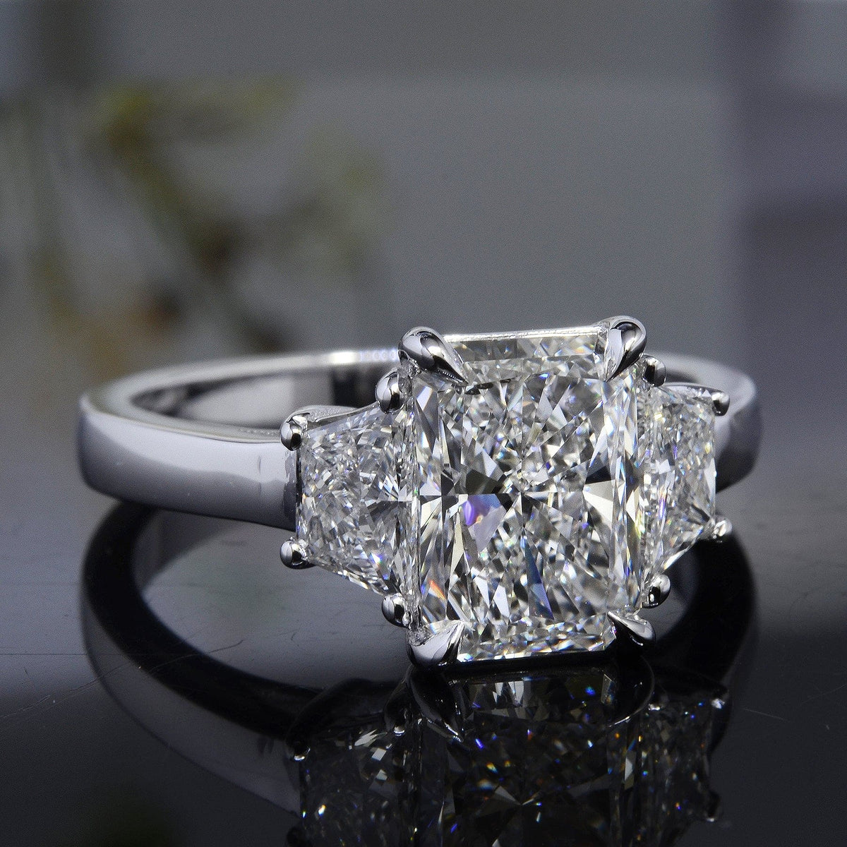 Elongated radiant cut center with trapezoid side 3 stone diamond ring in white gold