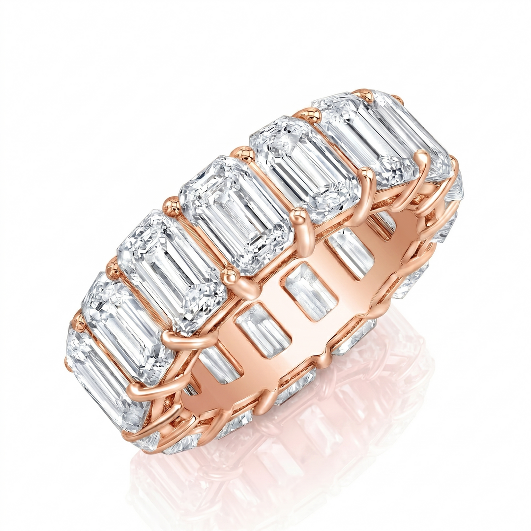 Rose gold ring with emerald-cut diamonds on a white background
