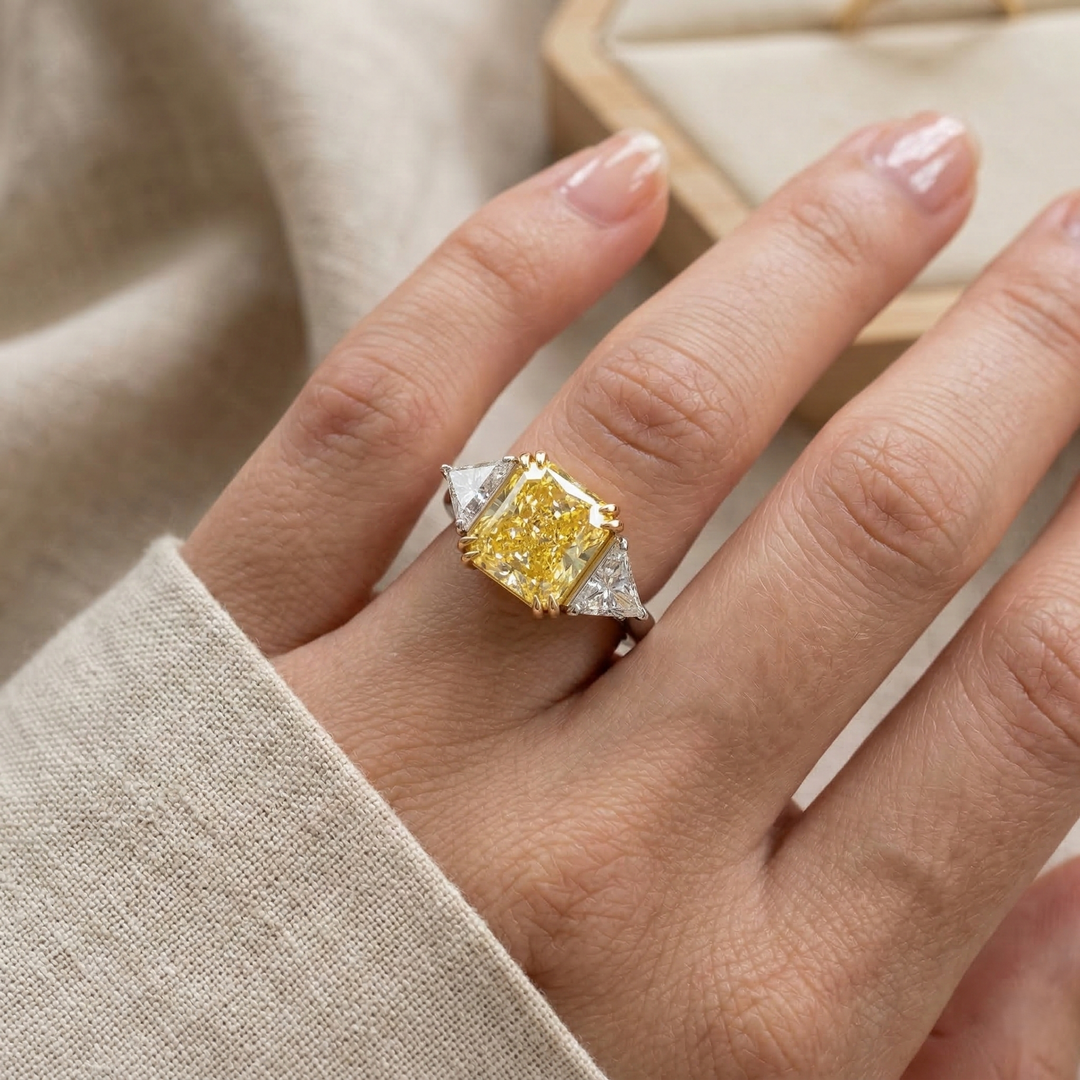 Three Stone Canary Radiant cut with Trillions on the side on model's Hand
