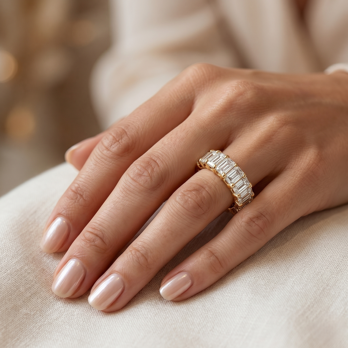 Yellow gold 8ct emerald cut diamond eternity on a models finger