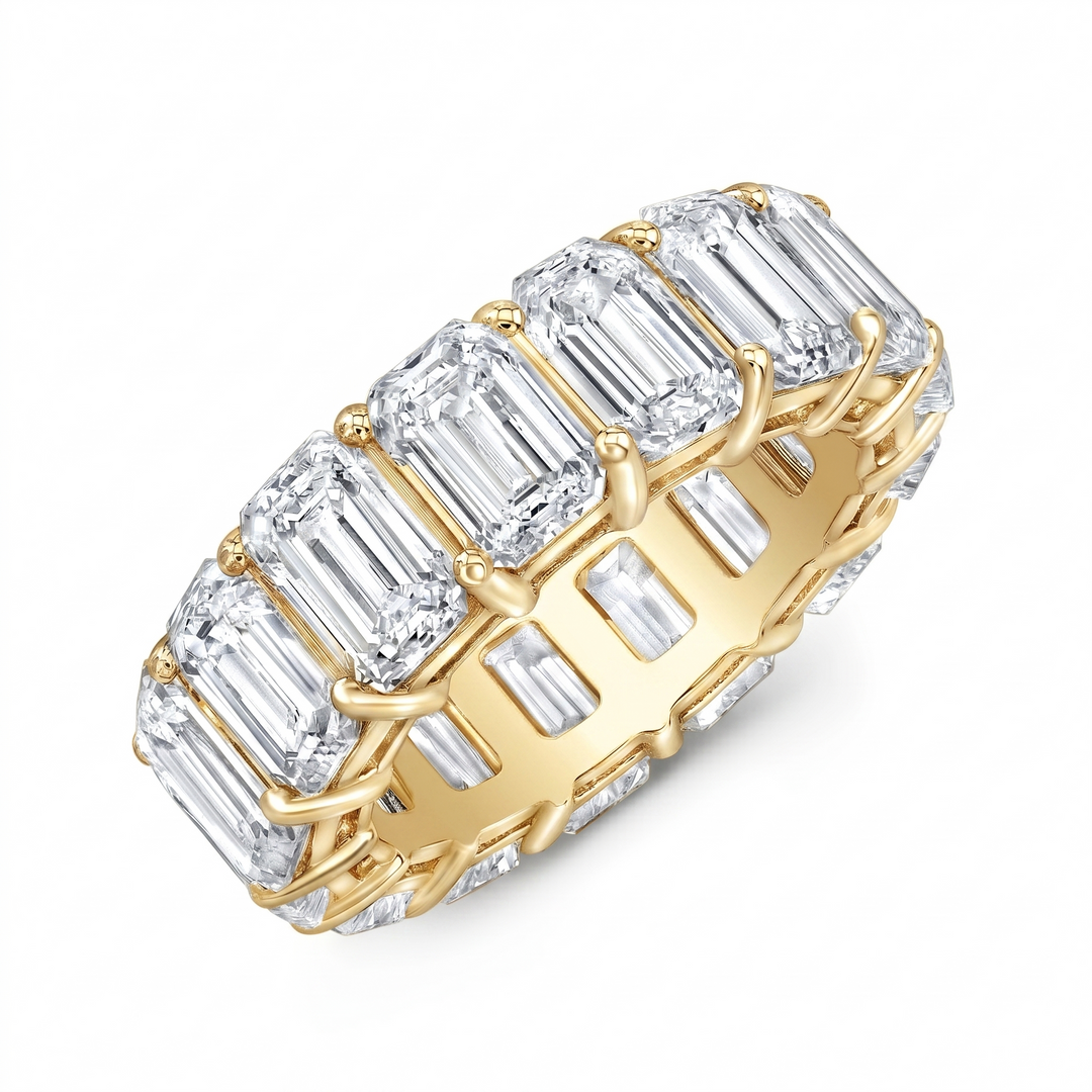 Gold ring with emerald-cut diamonds on a white background