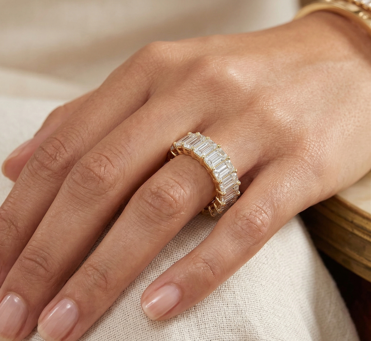 Yellow gold emerald cut eternity on model's finger
