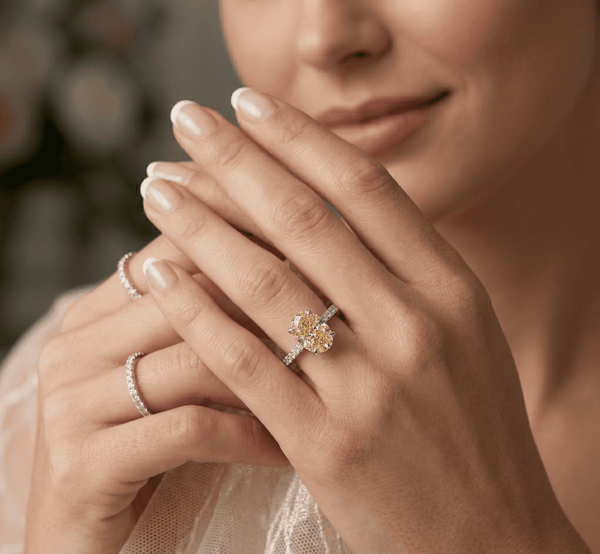 Close-up of a woman's hands wearing canary oval ring.