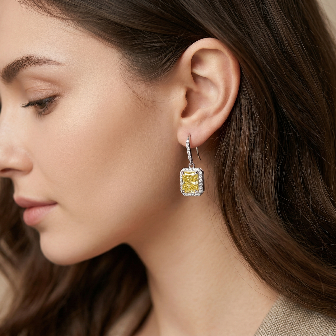 Close-up of a woman wearing a diamond earring with a yellow diamond