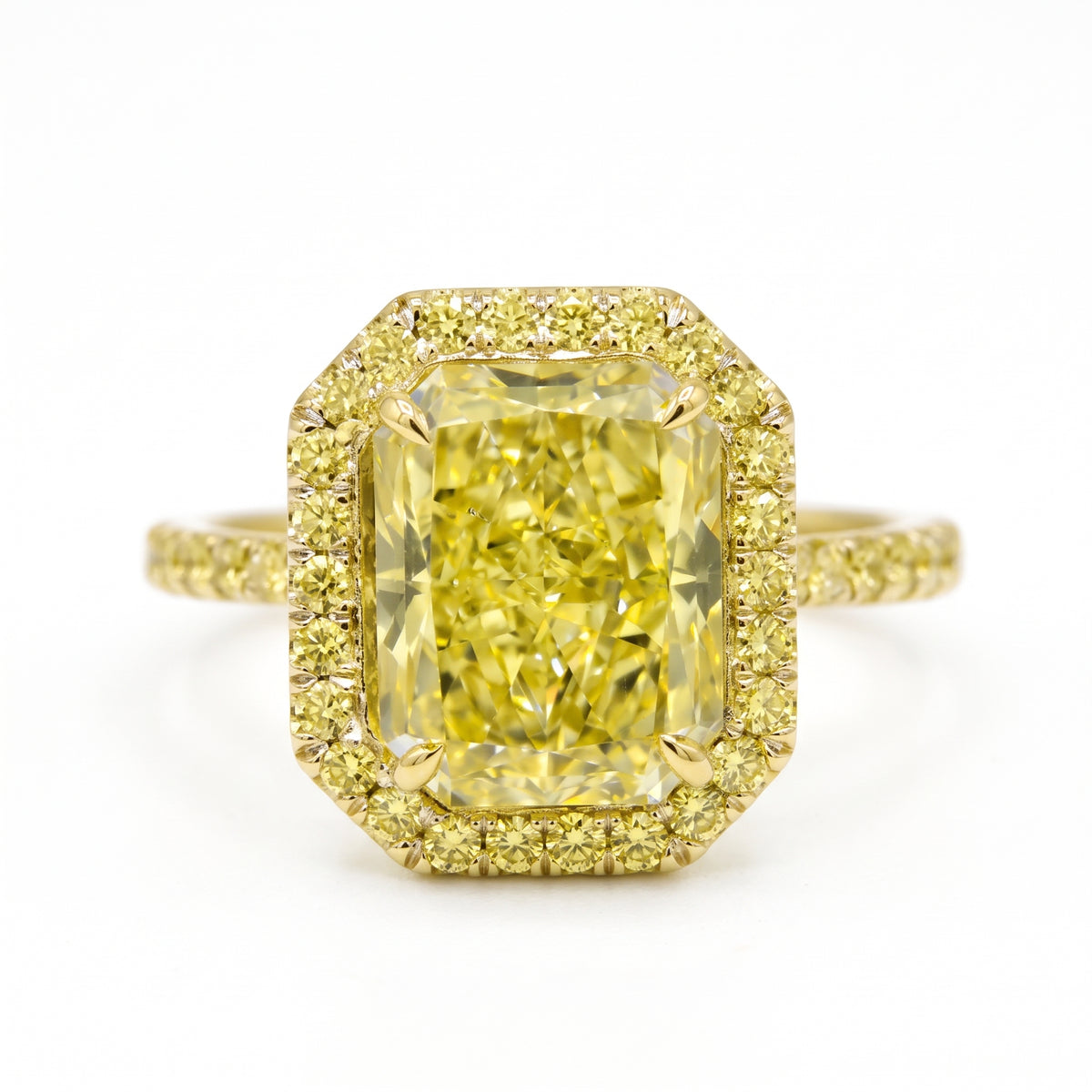 Elongated_yellow_radiant_cut_on_yellow_gold_halo_setting_white_background