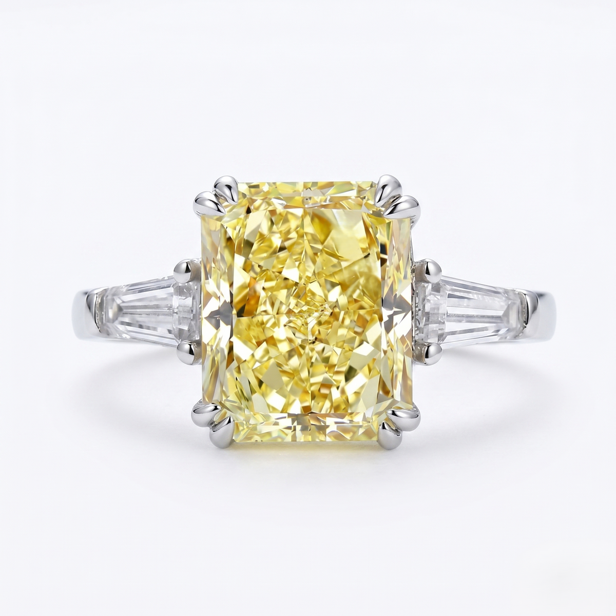 Yellow radiant cut and baguette ring with white gold setting on a white background