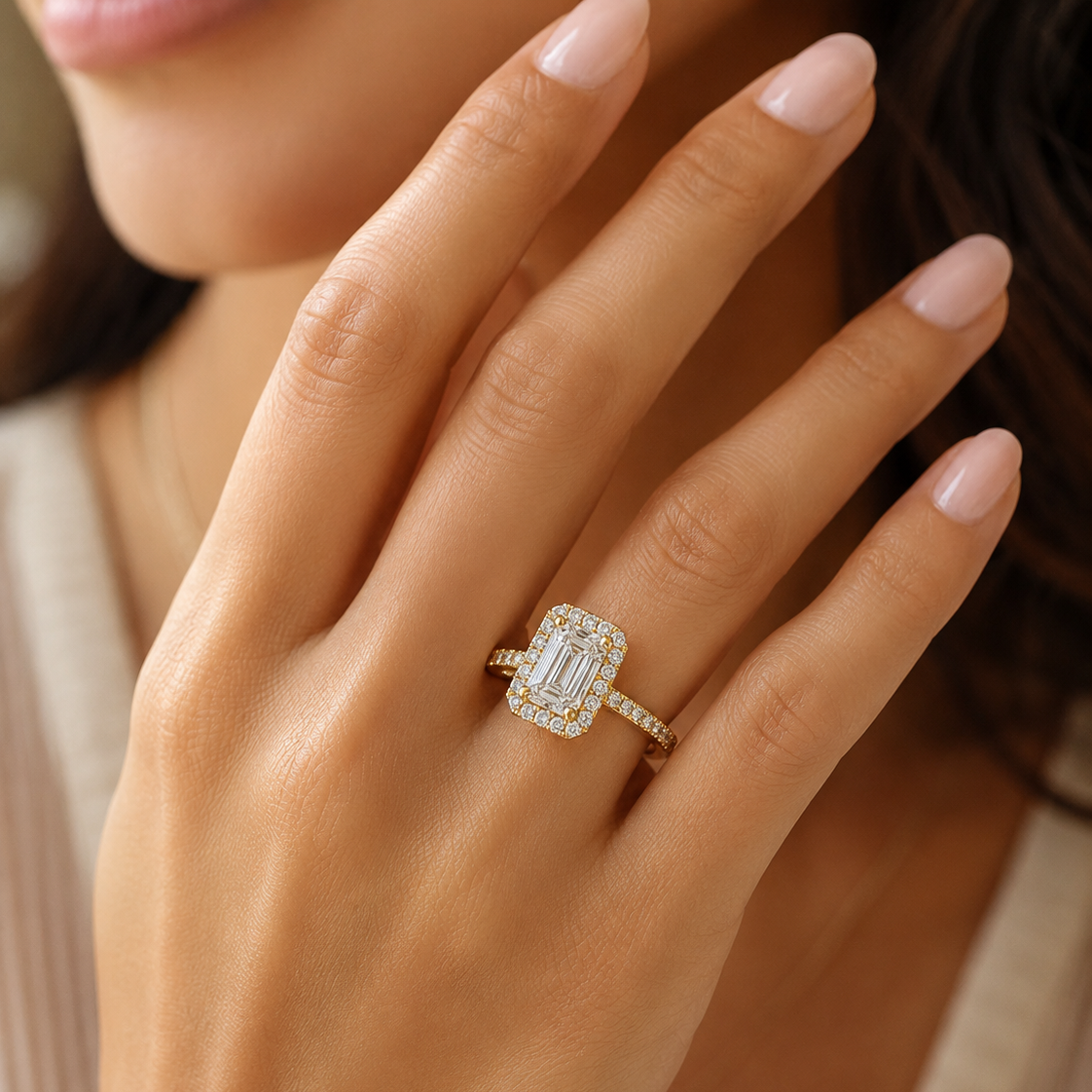 Halo emerald cut diamond ring on a model's finger