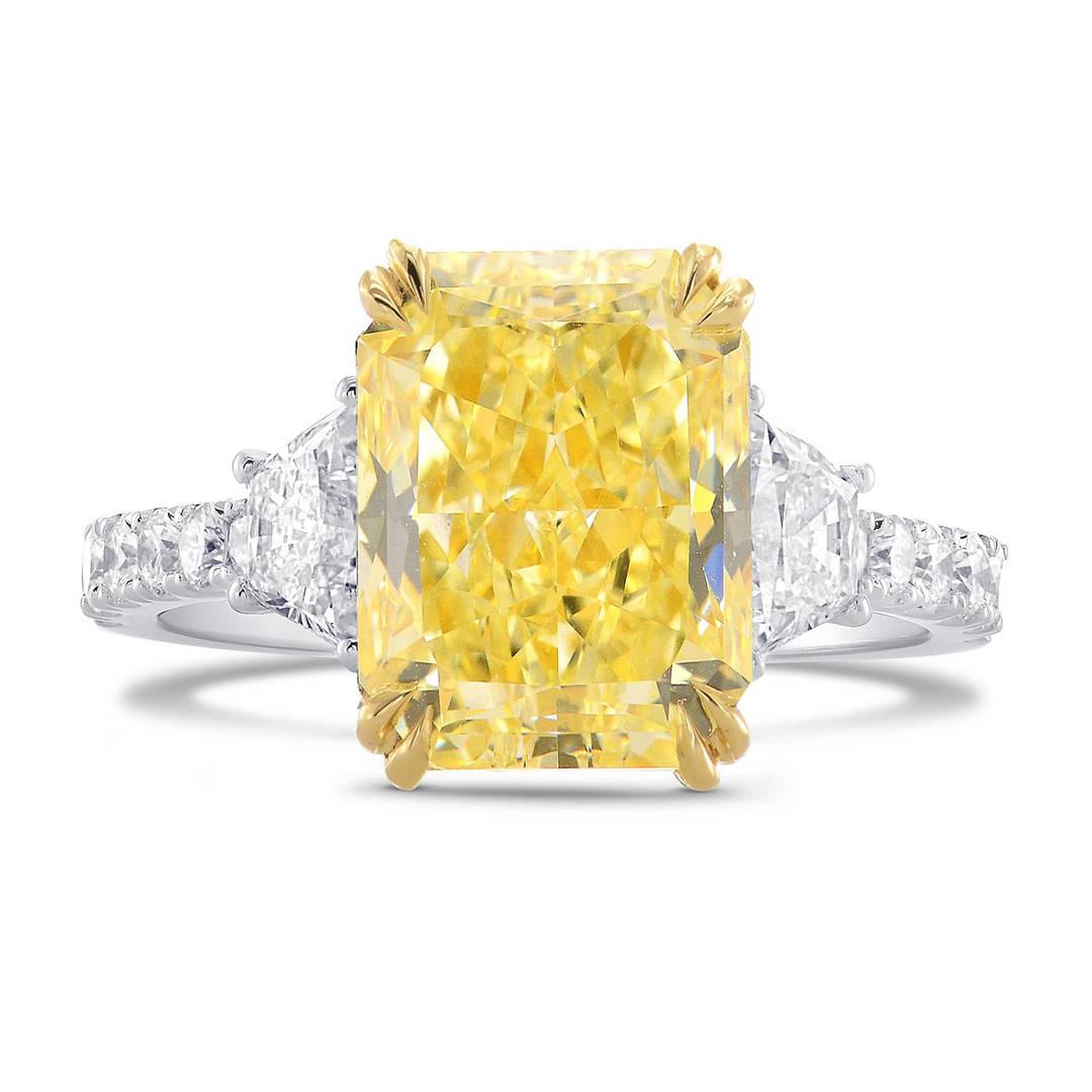 elongated radiant cut Yellow diamond ring with diamond-studded band on a white background