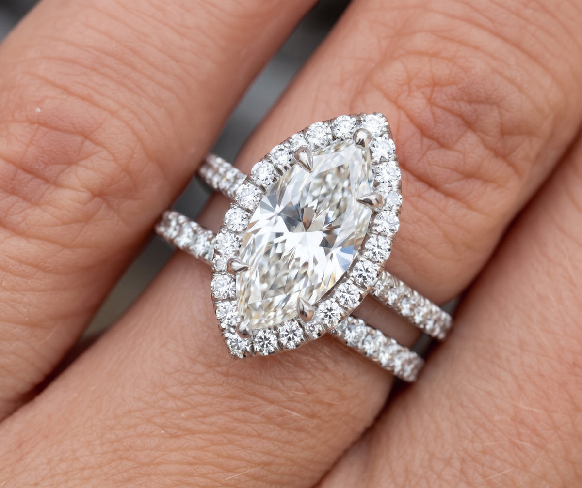 Marquise halo diamond ring and matching band on finger