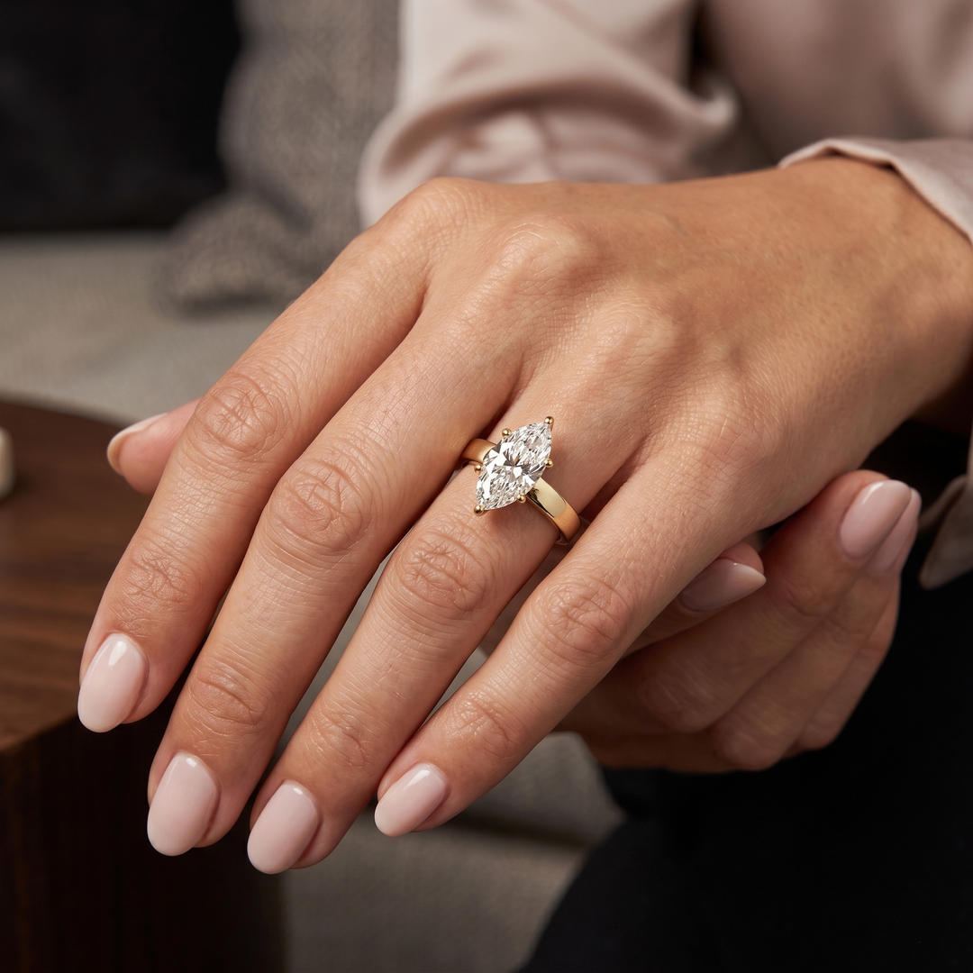 marquise solitaire wide band ring in yellow gold on a lady hand model