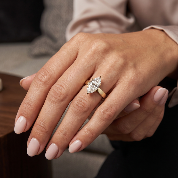 marquise solitaire wide band ring in yellow gold on a lady hand model