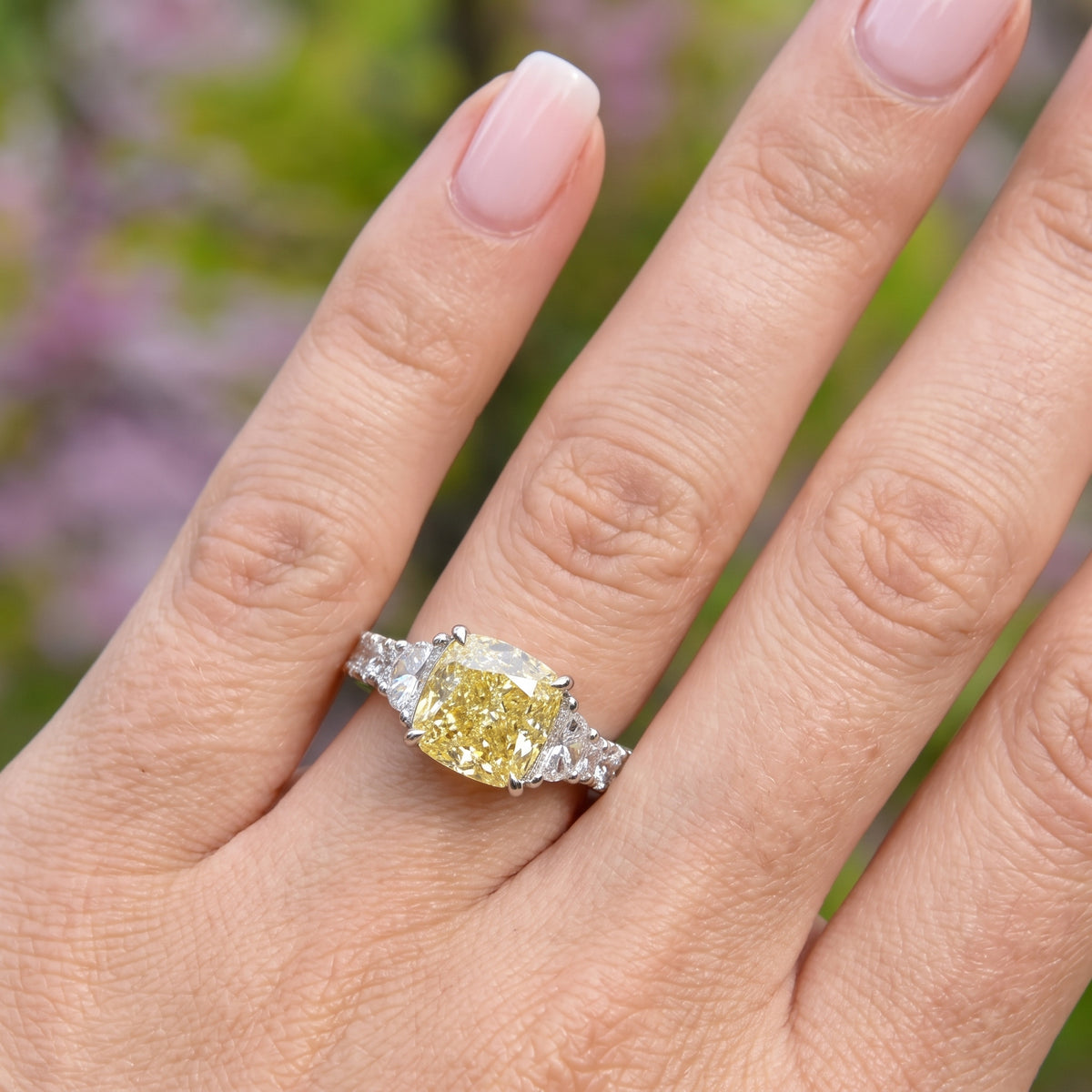 Model wearing yellow cushion and half moon with big round cut stones on the shank diamond ring