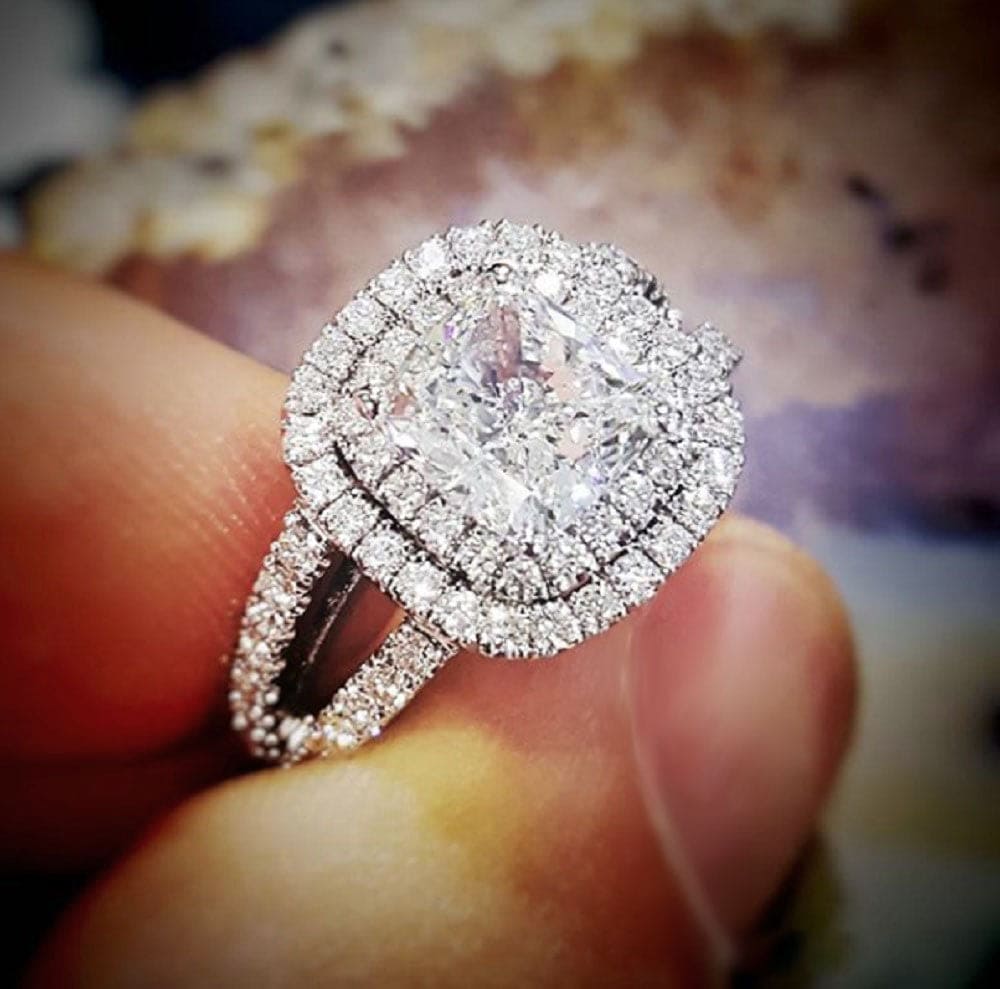 Double halo cushion engagement ring on hand