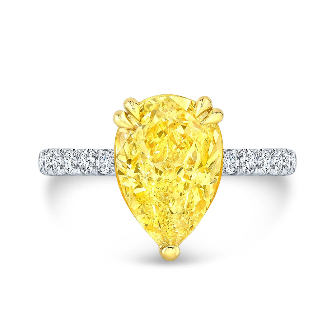 Pear cut yellow center diamond ring in  white gold band with yellow gold prongs 