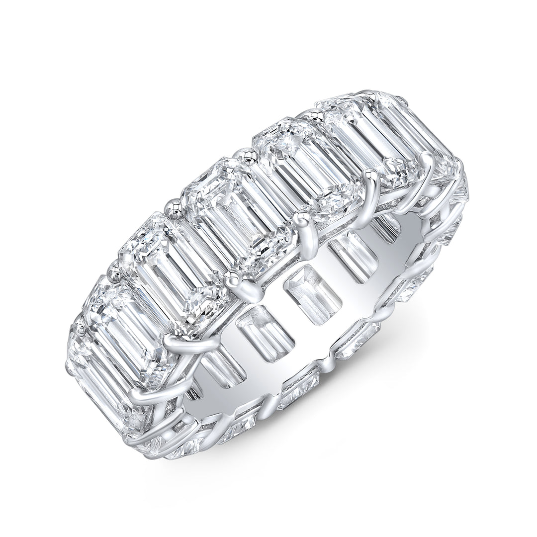 Diamond ring with emerald-cut stones on a white background