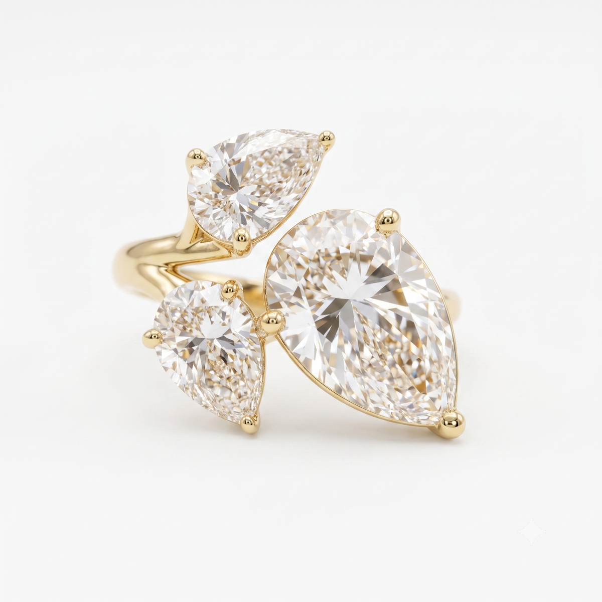 A yellow gold ring featuring three pear cut clear gemstones in a cluster setting, photographed on a clean white background