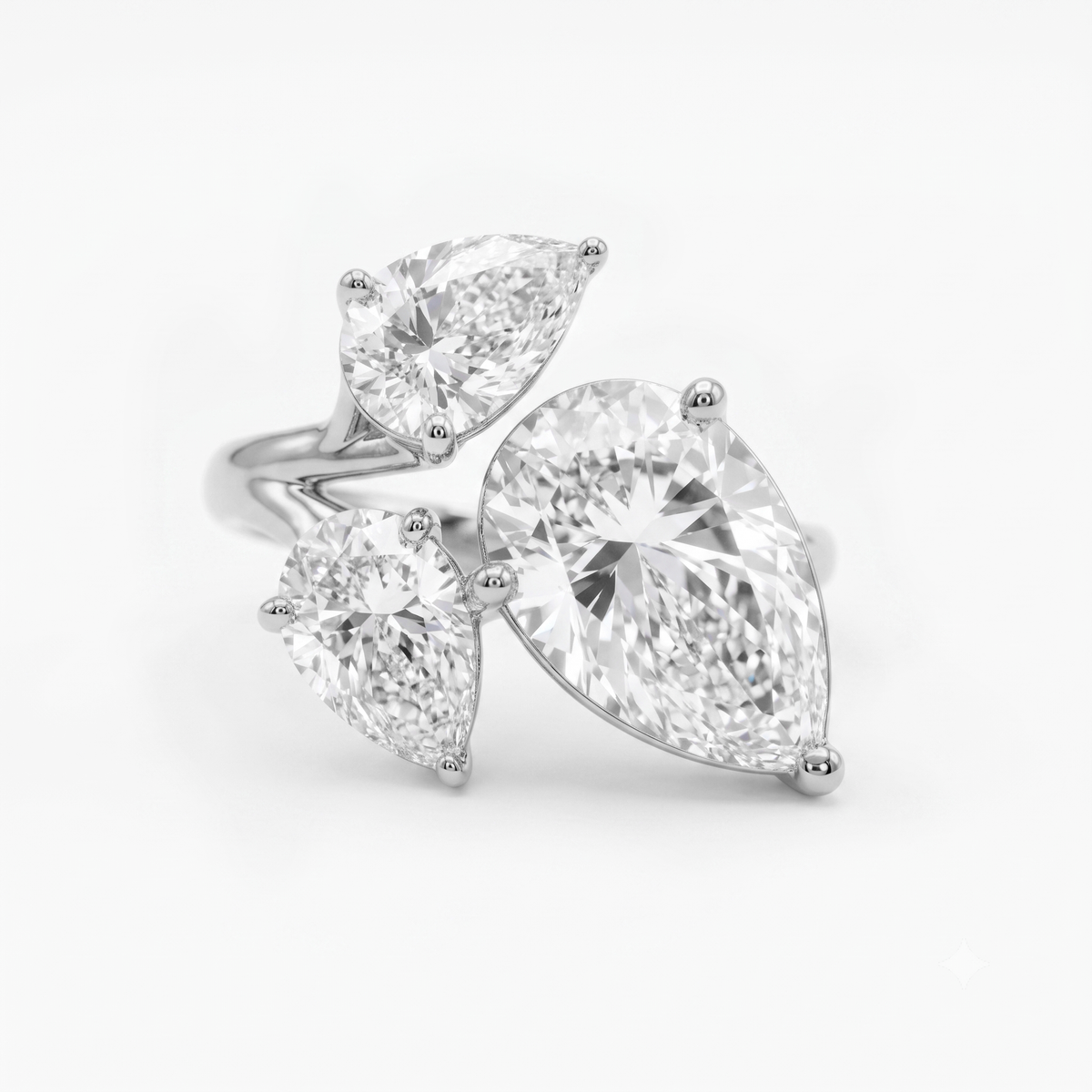 A silver tone ring featuring three pear cut clear gemstones in a cluster setting, photographed on a clean white background
