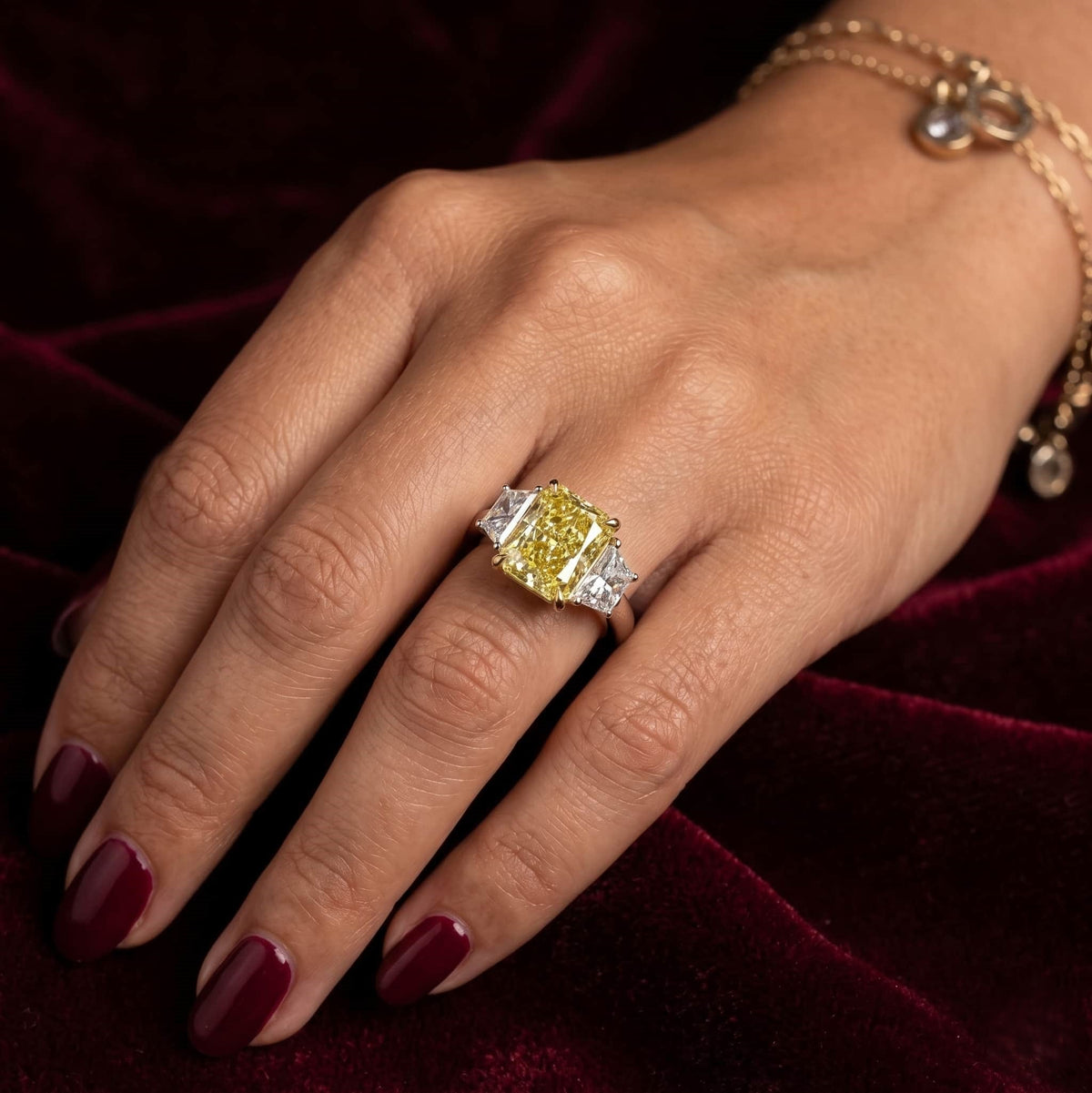 Three stone yellow elongated radiant with trapezoids on hand