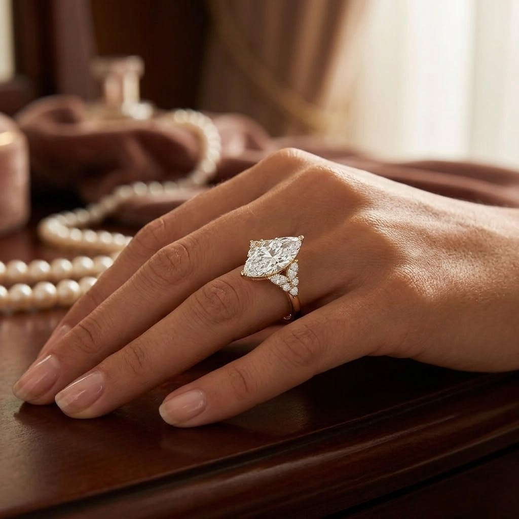 Marquise center diamond ring with side marquise and round cut in yellow gold on model hand