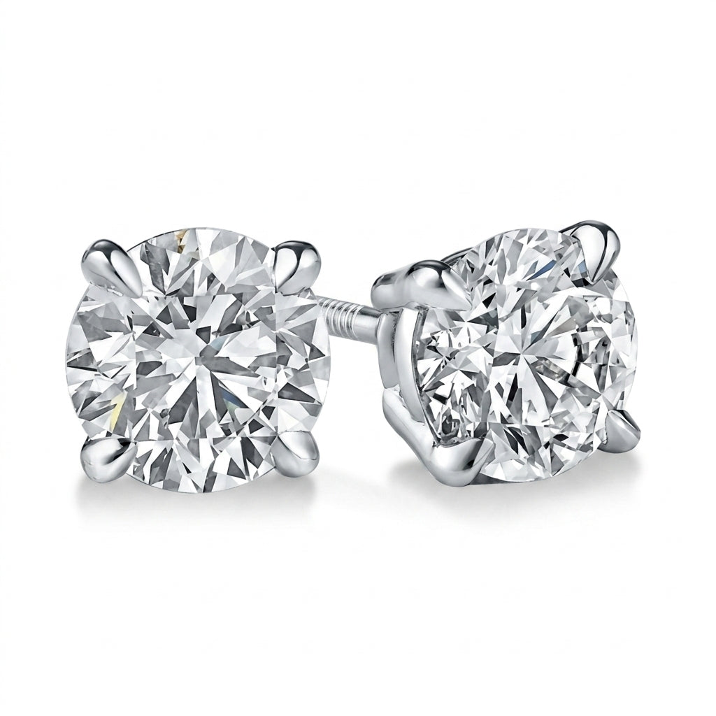 A pair of round-cut diamond stud earrings in a white gold four-prong setting, shown on a clean white background.