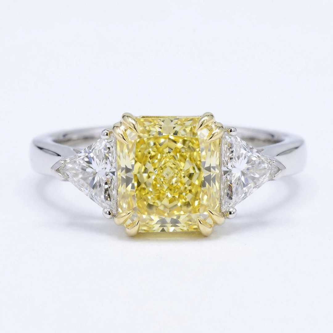 Diamond ring with a yellow center stone on a white background