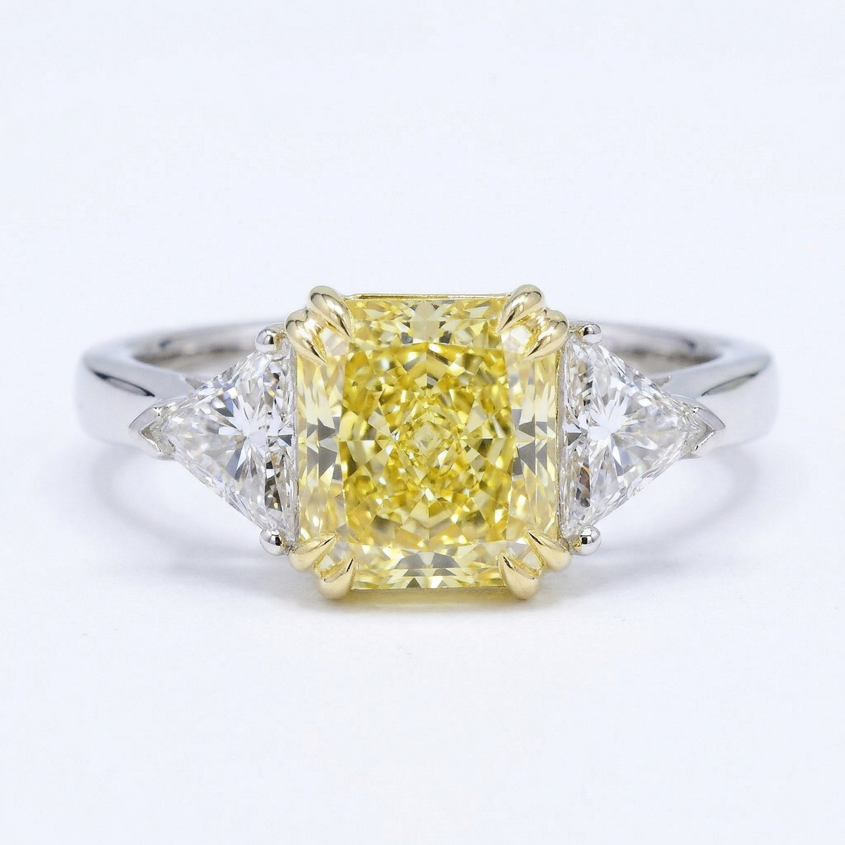 Diamond ring with a yellow center stone on a white background