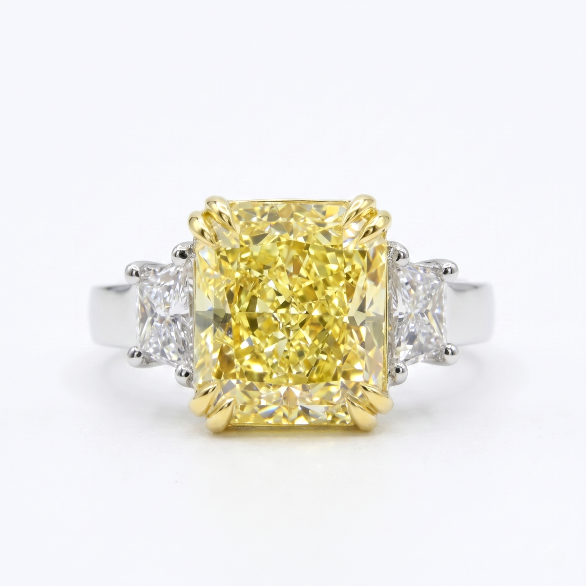 Yellow elongated radiant with trapezoids three stone ring on a white background