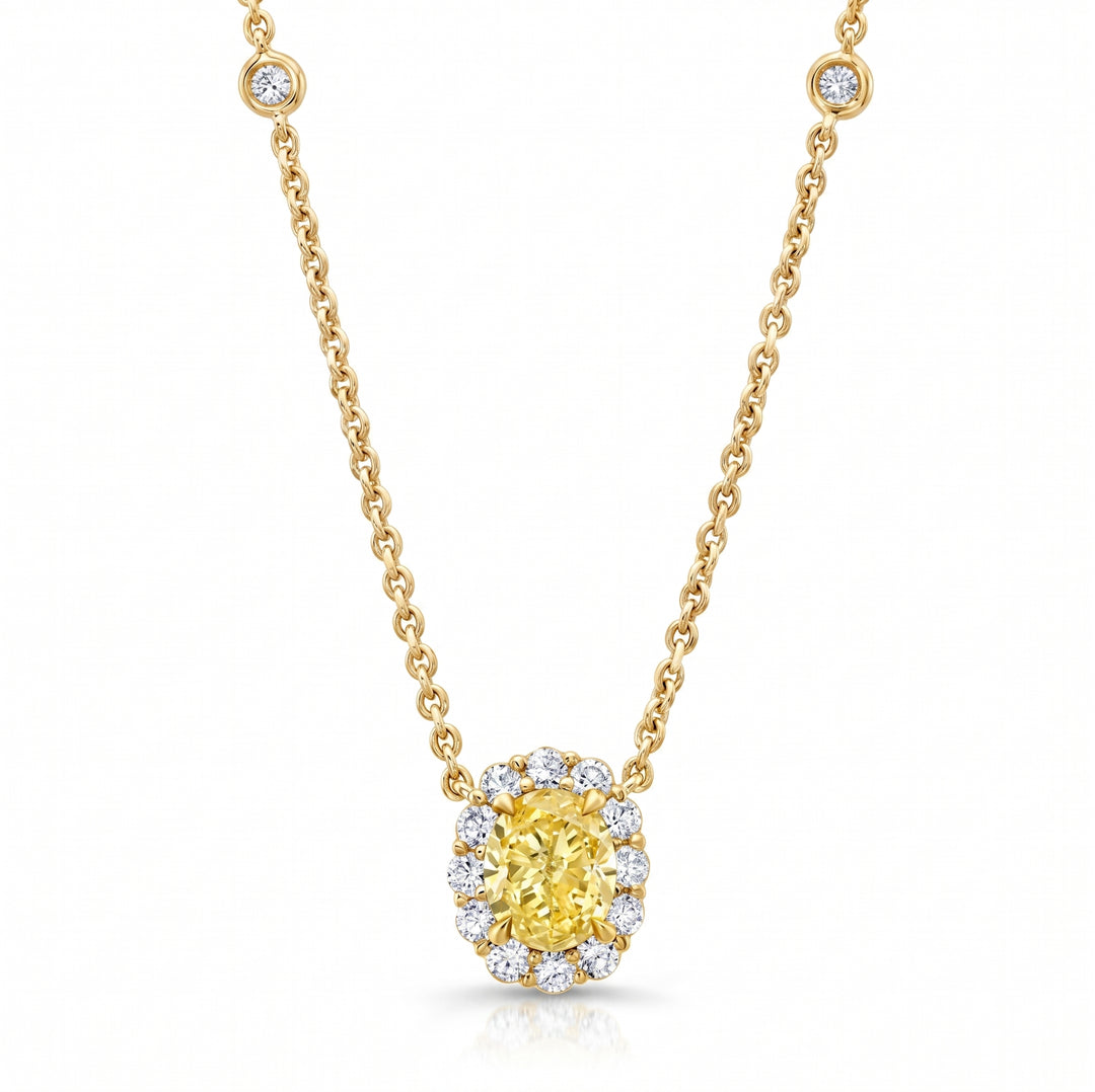 A yellow diamond halo pendant necklace on a gold chain, set against a clean white background.