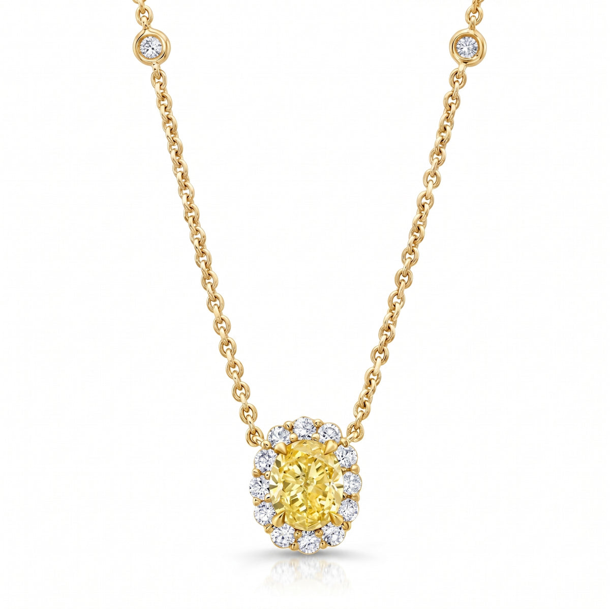 A yellow diamond halo pendant necklace on a gold chain, set against a clean white background
